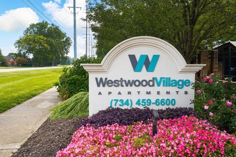 a sign apartments in front of pink flowers